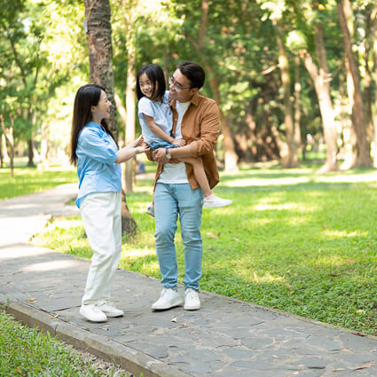 happy family of 3 walking outdoors