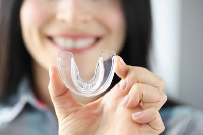 closeup of lady holding a clear mouthguard