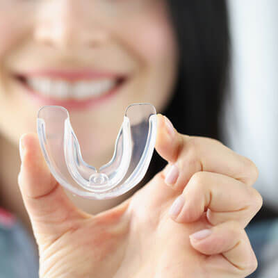 closeup of woman holding clear mouthguard