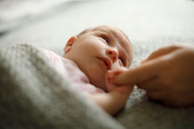 Baby holding moms finger