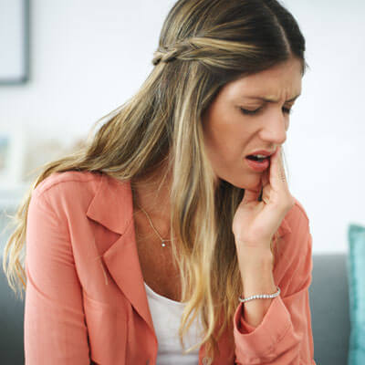 woman holding jaw in pain