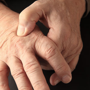 closeup of man holding hand in pain