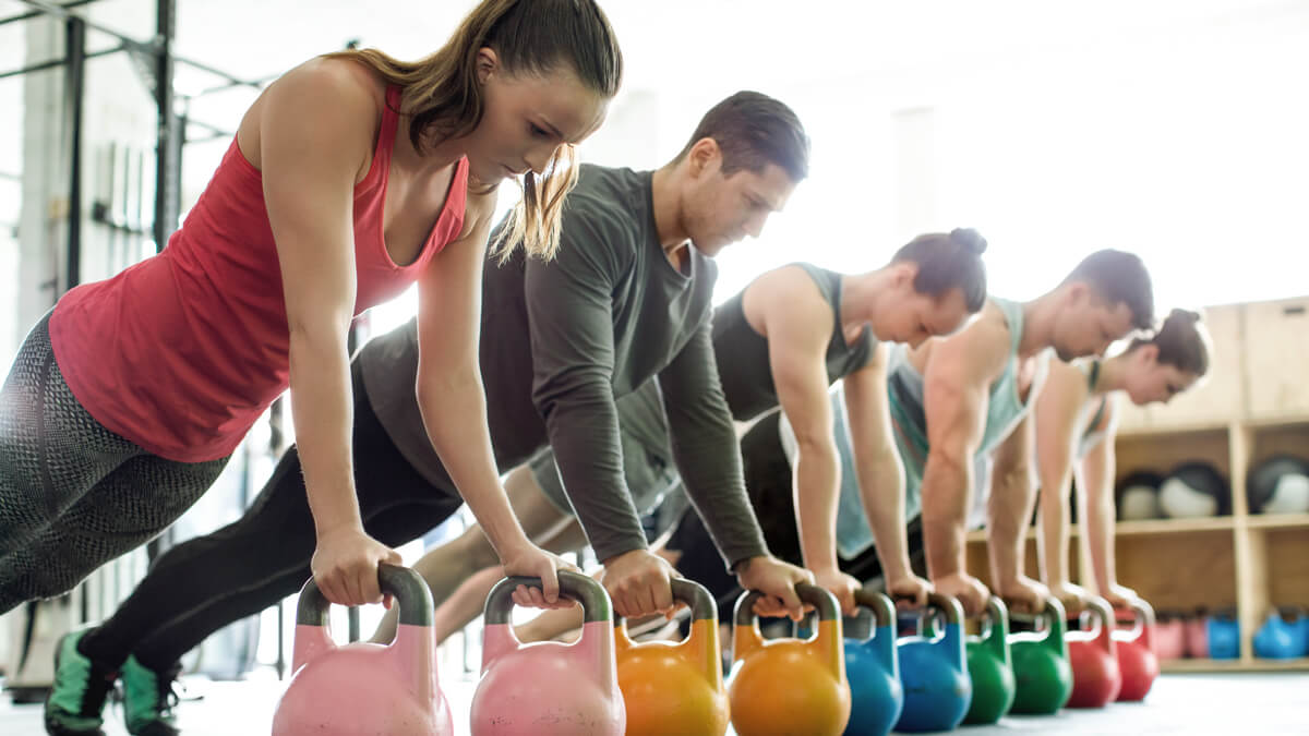 Group of people doing Kettle bell planks