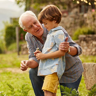 little boy gardening with grandfather