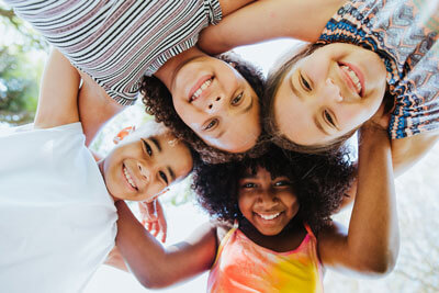 smiling kids in a circle looking down at the camera