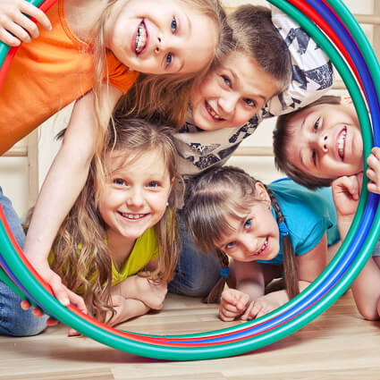 kids smiling through hula hoops
