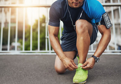 man lacing up his running shoes