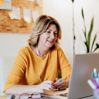 smiling person at desk working on computer