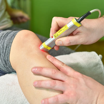 person getting laser therapy on knee