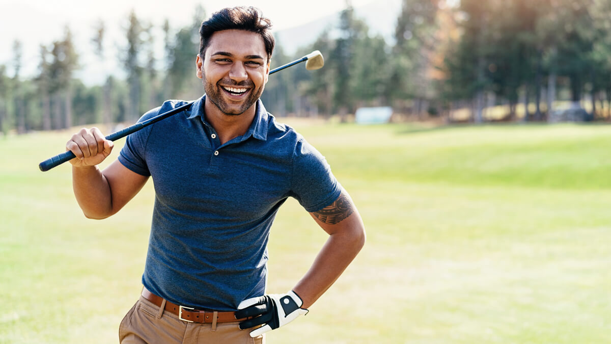 man playing golf smiling