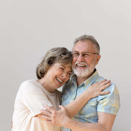 elderly couple laughing and hugging