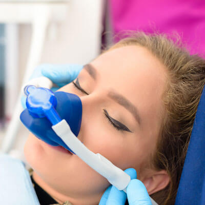 Woman with laughing gas over nose