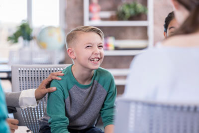 boy sitting in waiting room smiling