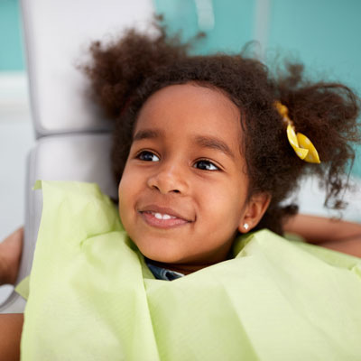 Little girl in chair with dental bib on