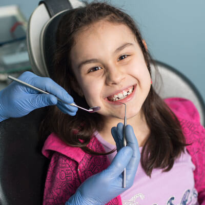 little girl having teeth cleaned
