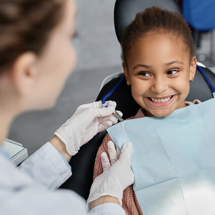 little girl smiling sweetly at hygienist