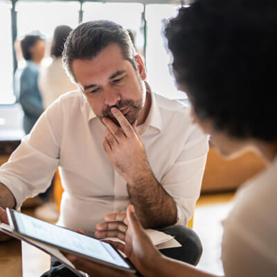 Two office workers looking at an tablet