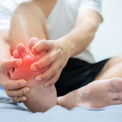 Man embracing foot in pain