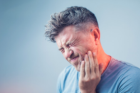 man clutching jaw in pain