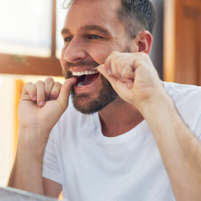 man flossing in mirror