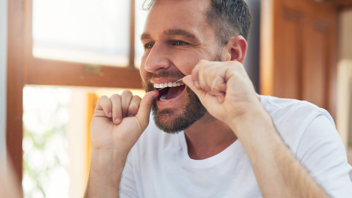 Man flossing his teeth