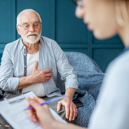 Man holding chest in consultation