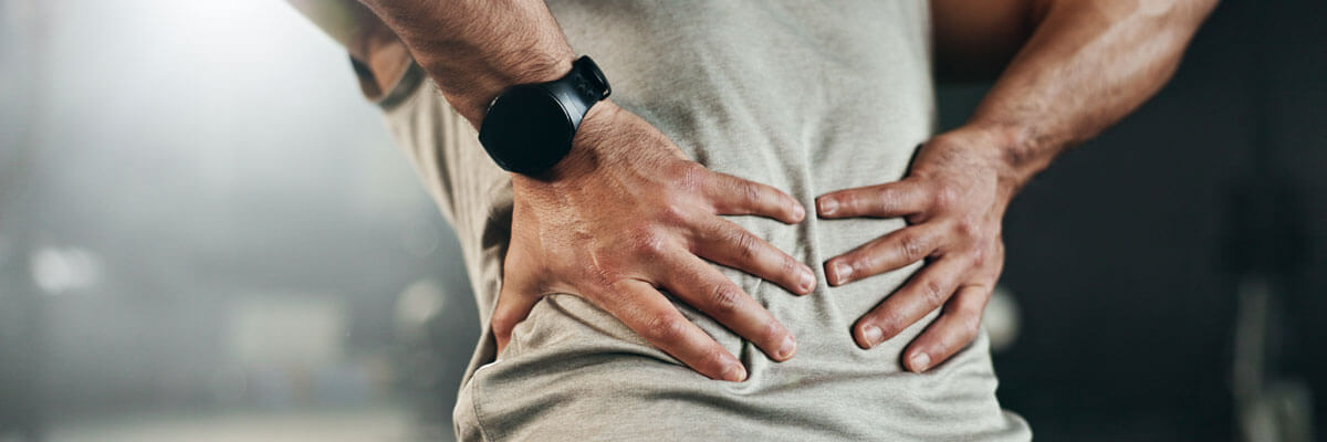 man holding lower back with both hands