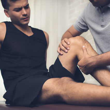 Chiropractor adjusting patient's knee
