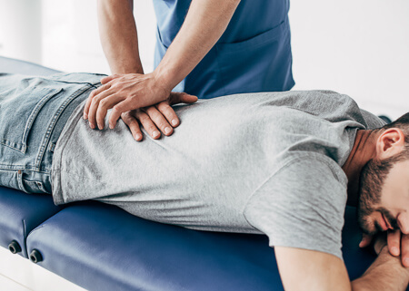 Chiropractor assessing a patient's lower back