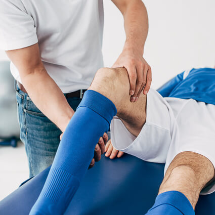 Man in soccer uniform having knee adjusted