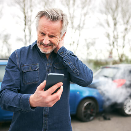 man looking at phone with neck pain