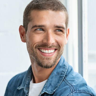 man looking out window with white teeth