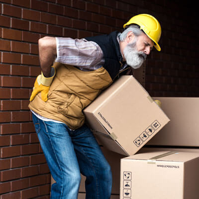Man with low back pain moving boxes