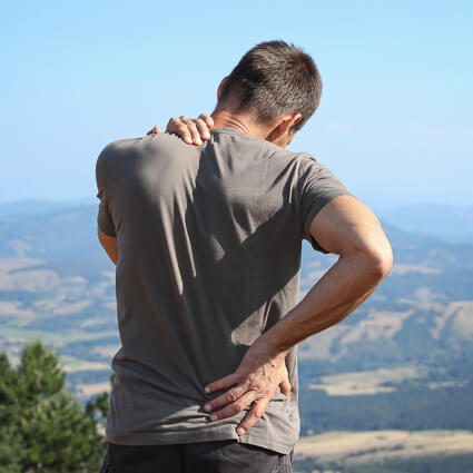 Man holding neck and back after a hike