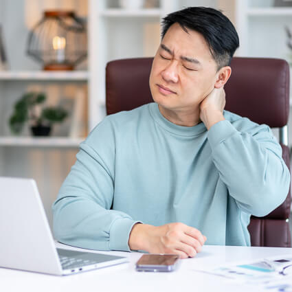 man working at computer with neck pain
