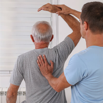 man with arm above head having shoulder adjusted