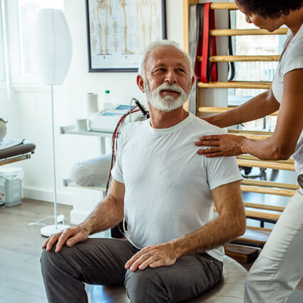 Man with beard white t-shirt having shoulder examined