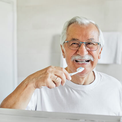 Older man brushing his teeth