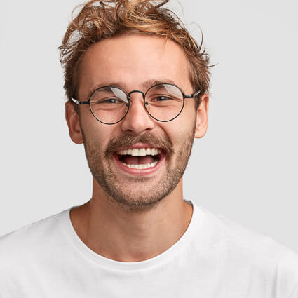 man with round glasses and open smile