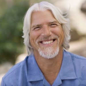 Older smiling man with white hair and beard