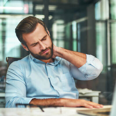 man working in city with neck pain