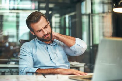 man working in city with neck pain