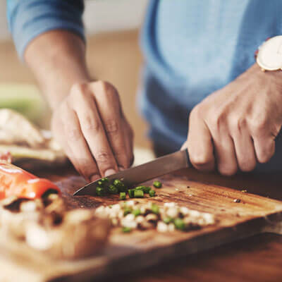 mans hands chopping veggies