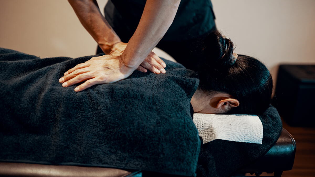 A woman receiving a chiropractic adjustment to her back