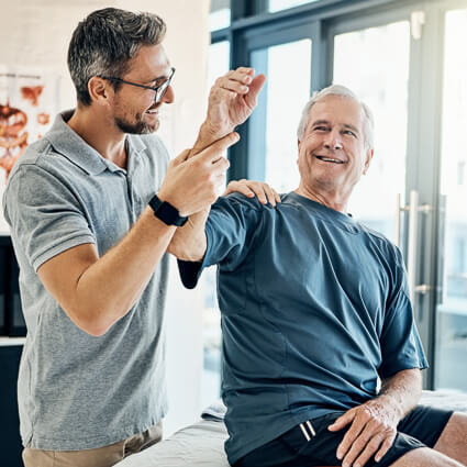 Mature man smiling while his arm is examined