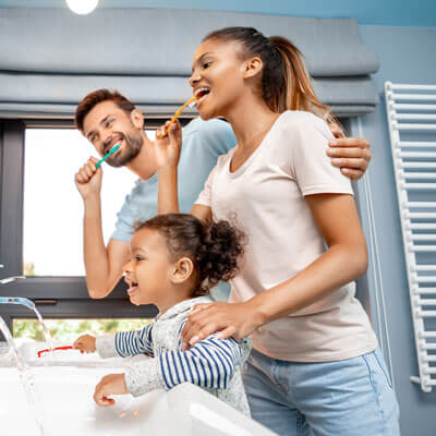 smiling family brushing their teeth