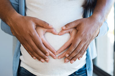 Heart hands on pregnant belly