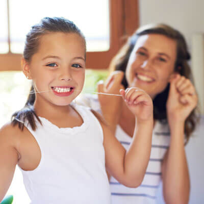 mom and kid flossing teeth