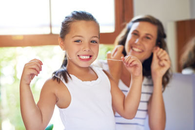 Girl flossing her teeth