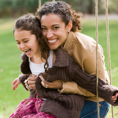 happy mom and kid swinging